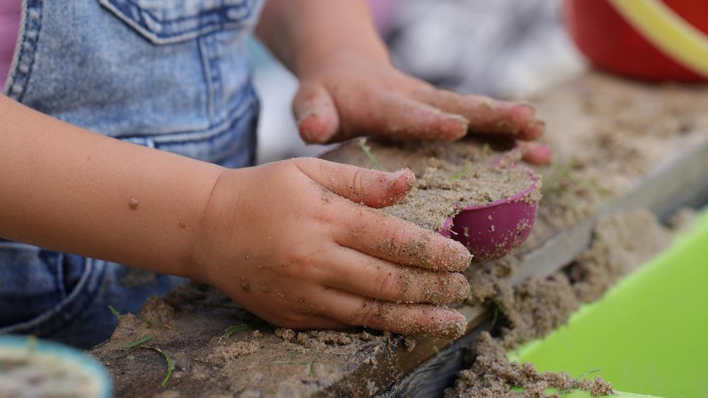 Kinderhände am Sandkasten