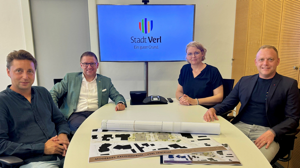 Gruppenbild am Tisch mit Plänen Gruppenbild am Tisch mit Plänen